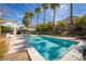 Beautiful backyard pool surrounded by manicured landscaping and towering palm trees, creating a private oasis at 2287 Moresca Ave, Henderson, NV 89052