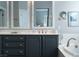 Elegant bathroom with blue vanity cabinets, white countertops, mosaic-trimmed mirrors, and gold fixtures at 2287 Moresca Ave, Henderson, NV 89052