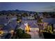 Stunning twilight aerial view of a home highlighting its pristine landscaping, inviting exterior lighting, and peaceful neighborhood at 2287 Moresca Ave, Henderson, NV 89052