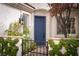 Inviting front entrance with a blue door, garden gate, and lush greenery at 2287 Moresca Ave, Henderson, NV 89052