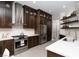 Spacious kitchen with dark wood cabinetry, stainless steel appliances, and white countertops at 2287 Moresca Ave, Henderson, NV 89052