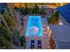 Inviting backyard pool with ambient lighting, lounge chairs, umbrella and lush greenery, enhanced by efficient solar panels at 2287 Moresca Ave, Henderson, NV 89052