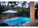 Backyard features a refreshing swimming pool, lounge chairs, a sun umbrella, and lush landscaping, perfect for outdoor relaxation at 2287 Moresca Ave, Henderson, NV 89052
