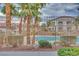 Community pool surrounded by tropical landscaping and multiple buildings with a wrought iron fence at 2305 W Horizon Ridge Pkwy # 514, Henderson, NV 89052