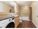 Well-lit bathroom featuring tiled walls, a washing machine, and a shower over the tub at 2405 W Serene Ave # 631, Las Vegas, NV 89123
