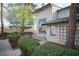 Stucco townhome with lush landscaping, showcasing its well-maintained exterior and curb appeal at 2430 Old Forge Ln # 106, Las Vegas, NV 89121