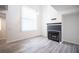 Open living space with a fireplace and modern flooring, illuminated by ample natural light at 2430 Old Forge Ln # 106, Las Vegas, NV 89121