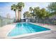 Community pool surrounded by lush trees and a metal fence on a sunny day at 2430 Old Forge Ln # 106, Las Vegas, NV 89121