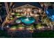 An aerial nighttime view of a backyard featuring a sparkling pool, spa, and beautifully landscaped grounds at 2824 Soaring Peak Ave, Henderson, NV 89052