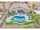 Aerial view of a landscaped backyard with a custom pool, spa, patio, and manicured lawn at 2824 Soaring Peak Ave, Henderson, NV 89052