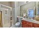 Bathroom featuring a glass enclosed shower and cherry vanity cabinet with white sink at 2824 Soaring Peak Ave, Henderson, NV 89052