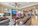 Comfortable living room featuring leather furniture, a ceiling fan, and an adjacent eat-in kitchen at 2824 Soaring Peak Ave, Henderson, NV 89052