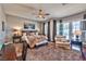 A comfortable main bedroom with a ceiling fan, a lounge chair, and natural lighting at 2824 Soaring Peak Ave, Henderson, NV 89052