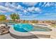 Inviting backyard pool and hot tub with clear blue water, framed by desert landscaping and a scenic mountain view at 2824 Soaring Peak Ave, Henderson, NV 89052
