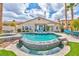 Beautiful backyard pool with a unique design, surrounded by lush landscaping and a cozy outdoor seating area at 2824 Soaring Peak Ave, Henderson, NV 89052