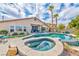 Inviting backyard pool and spa with lush landscaping, palm trees, and lounge chairs for relaxing outdoors at 2824 Soaring Peak Ave, Henderson, NV 89052