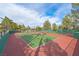 Wide shot of community tennis courts with green fences, nets, lighting, and mature trees at 2905 Haddon Dr, Las Vegas, NV 89134