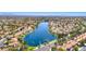 Stunning aerial view of a residential community built around a beautiful blue lake with mountain views in the background at 3125 N Buffalo Dr # 1136, Las Vegas, NV 89128
