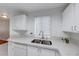 Well-lit kitchen featuring white cabinets, double stainless sink, and quartz countertops at 3125 N Buffalo Dr # 1136, Las Vegas, NV 89128