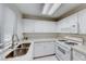 Bright kitchen featuring white cabinets, stainless steel sink, and modern gas range at 3125 N Buffalo Dr # 1136, Las Vegas, NV 89128