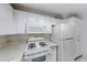 Kitchen featuring white cabinets, microwave, gas range, quartz countertops, and refrigerator at 3125 N Buffalo Dr # 1136, Las Vegas, NV 89128