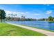 Scenic view of the lake and a grassy pathway with palm trees and a building on the opposite side of the water at 3125 N Buffalo Dr # 1136, Las Vegas, NV 89128