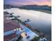 An aerial view of a home situated on a lake showing the infinity pool, outdoor seating and surrounding waterfront properties at 32 Grand Corniche Dr, Henderson, NV 89011