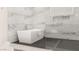 Modern bathtub with grey tile surround and glass shower partition at 32 Grand Corniche Dr, Henderson, NV 89011