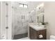 Modern bathroom featuring glass shower with marble tile and wood cabinet at 32 Grand Corniche Dr, Henderson, NV 89011