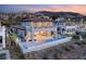 A luxurious two-story home features an infinity pool and an outdoor seating area with views of the mountain range at 32 Grand Corniche Dr, Henderson, NV 89011
