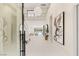 Elegant foyer with grand chandelier, staircase, and view of the lake visible through the living room at 32 Grand Corniche Dr, Henderson, NV 89011