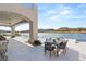 Outdoor dining area featuring a table for six on a well-lit patio overlooking the lake at 32 Grand Corniche Dr, Henderson, NV 89011