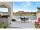 Covered patio with outdoor dining, stainless grill, and stunning lake and mountain views, ideal for entertaining at 32 Grand Corniche Dr, Henderson, NV 89011