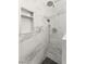 Close up of shower with marble tiles and shower head at 32 Grand Corniche Dr, Henderson, NV 89011