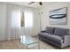 Bedroom with a soft gray couch, neutral carpet, bright white curtains and ceiling fan at 3331 Cheltenham St, Las Vegas, NV 89129