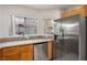 Kitchen with stainless steel refrigerator and dishwasher, wood cabinets, sink and a window at 3331 Cheltenham St, Las Vegas, NV 89129