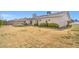 Wide shot of backyard with patio, sparse grass, fence, and surrounding greenery at 3492 Edison Ave, Las Vegas, NV 89121