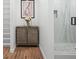 Modern bathroom featuring a marble shower, wood cabinet, and hardwood floors at 3492 Edison Ave, Las Vegas, NV 89121