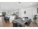 Open-concept dining area with gray dining table, modern chairs, hardwood floors, and a view of the kitchen at 3492 Edison Ave, Las Vegas, NV 89121