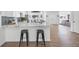 Open-concept kitchen with a large island, bar stool seating, white cabinets, and stainless steel appliances at 3492 Edison Ave, Las Vegas, NV 89121
