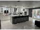 Modern white kitchen features a large island with seating, granite countertops, and stainless steel appliances at 3860 Ventura Way, Las Vegas, NV 89121