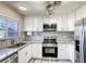 Modern kitchen features white cabinets, stainless steel appliances, and stylish herringbone backsplash at 3882 Cinnamonwood Way, Las Vegas, NV 89115