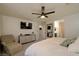 Bedroom featuring a ceiling fan, neutral walls, and a view into the ensuite bath at 394 Espressivo St, Henderson, NV 89011