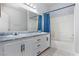 Bathroom features dual sinks with white cabinets and a shower with a blue curtain at 4820 Grey Wolf Ln # 101, Las Vegas, NV 89149
