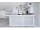 Modern kitchen with stainless steel appliances, white cabinets, a breakfast bar, and gray wood-look flooring at 4820 Grey Wolf Ln # 101, Las Vegas, NV 89149