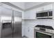 Stainless steel appliances, white cabinets, and modern backsplash featured in this kitchen at 4820 Grey Wolf Ln # 101, Las Vegas, NV 89149