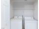 A laundry room with a white washer and dryer and a wire shelf for storage at 4820 Grey Wolf Ln # 101, Las Vegas, NV 89149