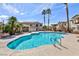 Community pool with palm trees and lush landscaping creating a tropical feel at 4820 Grey Wolf Ln # 101, Las Vegas, NV 89149