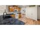 Kitchen featuring wood cabinets, dark countertops, and white appliances with wood flooring throughout at 5050 Nw Valdez Ct, Pahrump, NV 89060