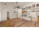 Open-concept living room with wood floors, a ceiling fan, and a breakfast bar looking into the kitchen at 5050 Nw Valdez Ct, Pahrump, NV 89060